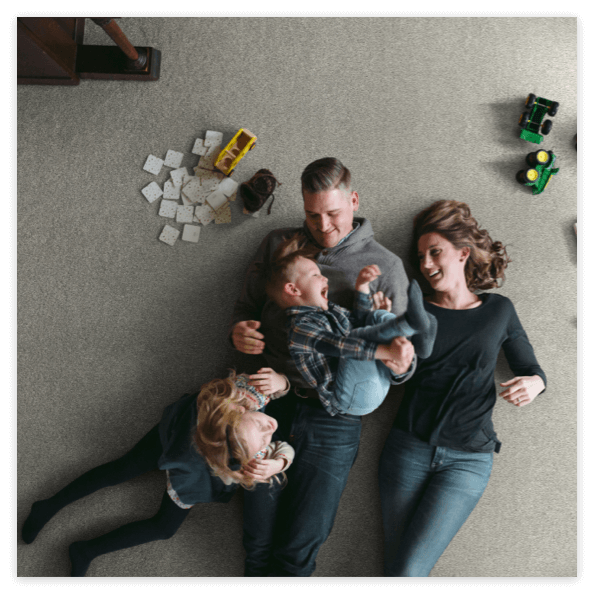 Happy family laying on soft carpet floor | Wall 2 Wall Flooring